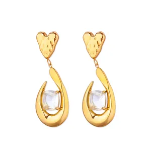Détail macro de boucles d'oreilles cœur évidé double couche au design géométrique doré