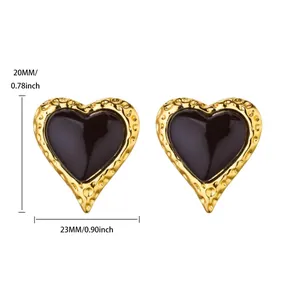 Macro-opname van hartvormige gouden oorbellen met zwart emaille en gehamerde textuur, 23mm