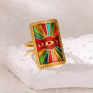 Detail of a gold rectangular ring with colorful enamel sunburst and Lucky lettering