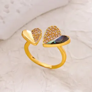 Macro detail of gold ring featuring pavé diamonds and iridescent dark shell heart charms