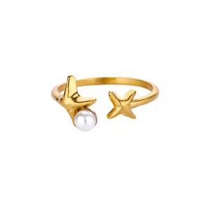 Detailed view of an open gold ring featuring two 3D star motifs and a white round pearl