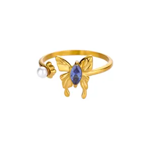 Detail view of gold butterfly ring with blue marquise stone and white pearl accent