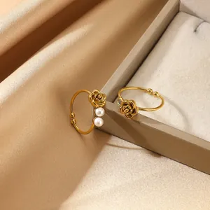 Elegant gold rose rings set with pearls and zircons on champagne satin background
