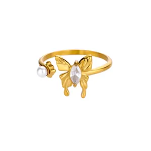 Detail of adjustable gold ring with sparkling butterfly zircon and white pearl accent