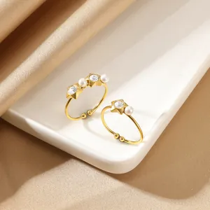 Gold star and pearl stainless steel stackable open rings on a satin background