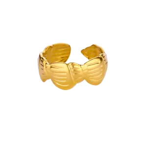 Detail of a golden twisted flower ring with polished texture and adjustable open band