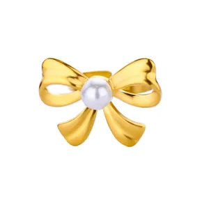 Detailed close-up of a golden bow ring featuring a polished finish and a central white pearl