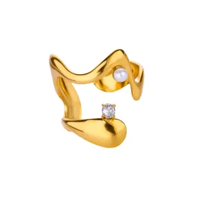 Detailed shot of a gold wavy ring featuring a small pearl and a sparkling zircon stone