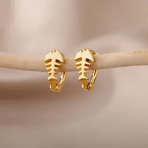 Elegant gold fishbone geometric hoop earrings displayed on a minimalist wooden stand