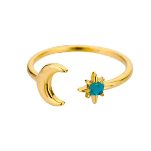 Detail of gold moon and star open ring featuring a blue gemstone with natural textures