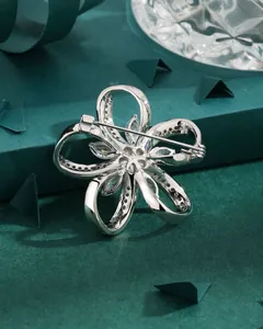 Detailed back view of a silver floral brooch showing its secure safety pin and structure