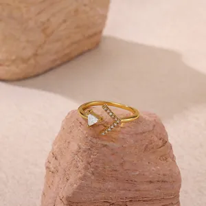 Detailed macro view of gold geometric ring with triangle zircon on a textured stone base