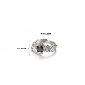 Detail view of silver ring with colorful round zircon and intricate branch-like design