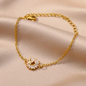 Elegante gouden armband met zirkonia bloemblaadjes en vlinderdetail op zijden achtergrond