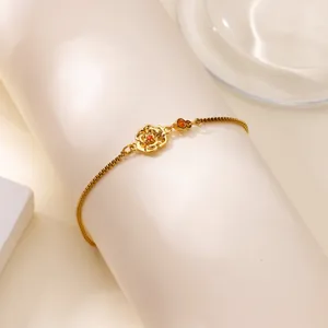 Gros plan détaillé d'un bracelet rose doré avec pierre jaune sur un cylindre blanc