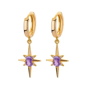 Detailed macro view of gold-plated star huggie earrings with purple center gemstone