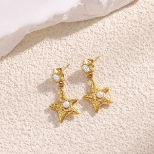 Starfish gold earrings with pearls and crystals on a sandy beige background