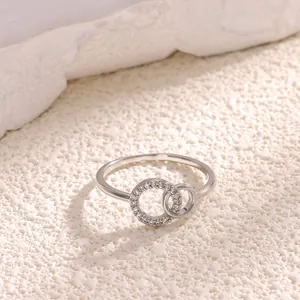 Detalle macro de anillos de plata entrelazados con pavé de circonitas y bandas pulidas