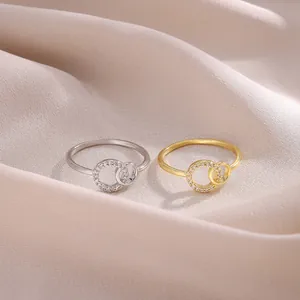 Detalle macro de un anillo doble entrelazado con circonitas sobre elegante seda champán