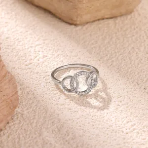Close-up of interlocking silver geometric rings with sparkling pave zircon settings