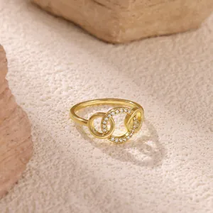 Macro shot of interlocking golden double rings featuring zircon pave on textured stone