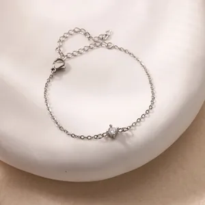 Macro shot of minimalist silver chain bracelet with round zircon and adjustable lobster clasp