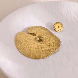 Back view of golden lotus leaf brooch with textured veins and secure butterfly pin clutch