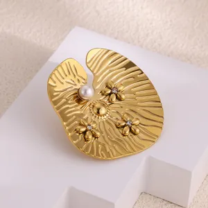 Detailed view of golden lotus leaf brooch with white pearl and sparkling small flowers
