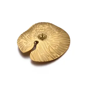 Detailed macro view of golden lotus leaf brooch with intricate radial metal texture