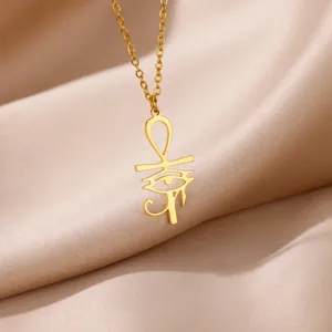 Detailed close-up of golden Ankh and Eye of Horus pendant on luxury silk background