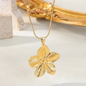 Dettaglio macro del ciondolo a fiore placcato oro 18 carati con finitura spazzolata su catena