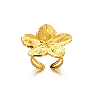 Close-up of golden flower ring with textured five-petal design and adjustable band