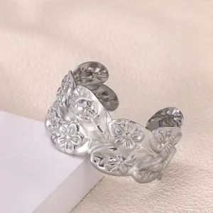 Primer plano del brazalete ancho abierto con relieve detallado de flores y hojas