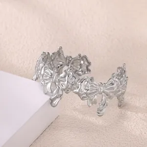 Detalle del diseño de lazo geométrico en el brazalete de acero inoxidable mate plata
