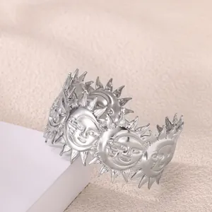 Detalle del diseño de relieve solar plateado en el brazalete abierto de acero inoxidable