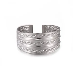 Detalle del brazalete de acero inoxidable plateado con bandas trenzadas y pulidas brillantes