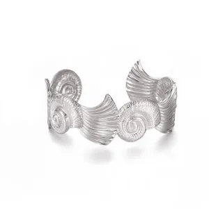 Vista detallada de los relieves de nautilus y conchas en un brazalete ancho de plata