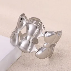 Detailed view of silver bow-shaped open bangle featuring polished metallic finish