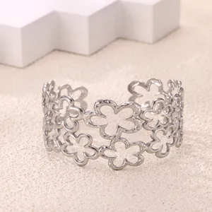 Detail of silver-colored hollow floral open bangle with delicate textured finish