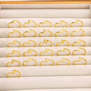 Set van 26 gouden verstelbare letterringen A-Z in een beige fluwelen juwelendoosje