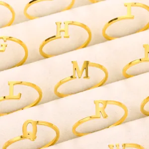 Detailweergave van gepolijste gouden letterringen in een elegant sieradentray