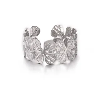Close-up of petal textured open ring with silver hammered finish and heart details