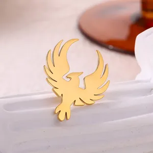 Macro shot of a golden phoenix bird brooch on a white textured stone pedestal