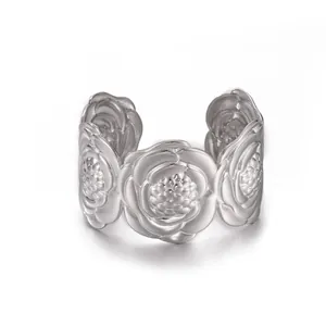 Macro shot of silver camellia flower metal cuff featuring detailed floral carving