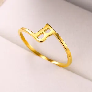 Detail van gepolijste gouden letter B ring op een beige juwelendoosje voor dames