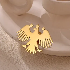 Detail of a vintage golden eagle brooch with star motifs on a textured ceramic surface