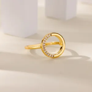 Dettaglio di un anello dorato multistrato con zirconi scintillanti su blocchi neutri