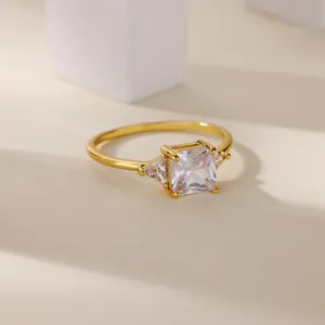Dettaglio di un anello in rame placcato oro con tre pietre di zircone a taglio quadrato