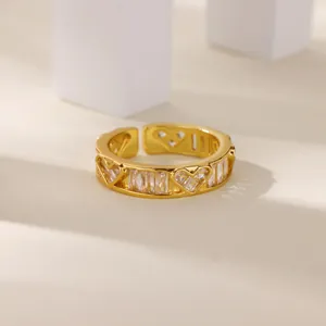 Dettaglio dell'anello dorato regolabile con cuori traforati e zirconi rettangolari