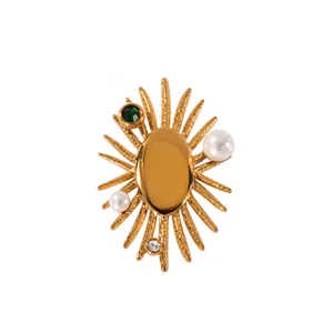 Elegant gold sunflower brooch with green gemstone and pearls on a white background